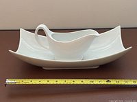 Gravy boat on underplate with measuring tape showing approx 12 in length