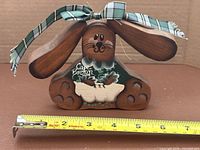 Front view of wood rabbit with ribbon and tape measure