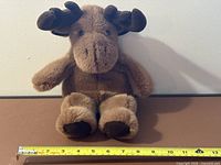 Front view of plush moose puppet with ruler for scale