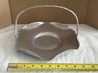 Top view showing full plate, scalloped shape, handle, and measuring tape for scale