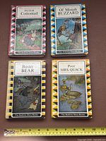 Front covers of all four Burgess Bedtime Story-Books with ruler for scale