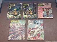 Group view of five Classics Illustrated comics showing all cover titles