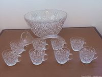 Punch bowl, eight cups, ladle displayed