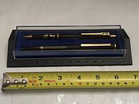 Pen and pencil in presentation case with tape measure for scale