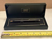 Pen inside open Cross case with measuring tape for scale