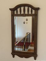 Full view of mirror showing frame design, arched top and bottom apron