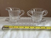 Full view of creamer, sugar bowl and tray with tape measure for scale