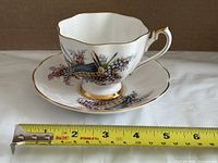 Cup on saucer with measuring tape showing size