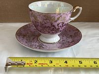 Cup on saucer beside ruler showing approximate 6 in. saucer diameter