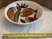 Top view of bowl showing full fruit motif and measuring tape across diameter