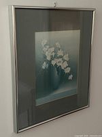 Framed print hung on wall showing full frame and hanger