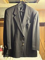 Full front view of black blazer on hanger
