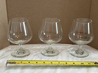 Front view of three brandy glasses with ruler for scale
