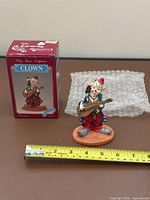 Figurine, box, bubble wrap, tape measure showing scale