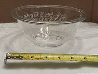 Angled view of entire clear Pyrex 322 bowl with tape showing approx. 7 in. diameter