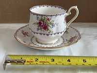 Teacup on saucer beside ruler showing approximate diameter