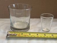 Both glasses side by side with tape measure for scale