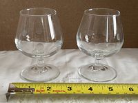 Front view of both polka dot glasses with tape measure for width reference