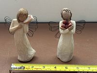 Front view of both Willow Tree angels with tape for scale