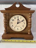 Front view showing dial, bezel, wood case and ruler for scale