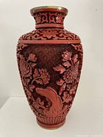 front view of vase showing floral carving and brass rim