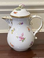 Front view of Meissen porcelain pot with floral decoration and rosebud lid