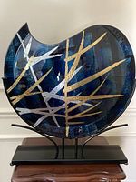 Front view of fused glass vase on black metal stand