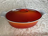 Casserole with lid on showing flame orange gradient exterior and integral handles