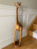 Full front view of the tall wood giraffe sculpture