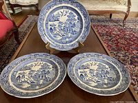 Three blue willow plates on table showing overall appearance