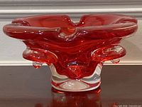 Side view showing red-orange body and clear base