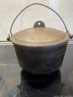 Front view of cast iron bean pot with lid and bail handle