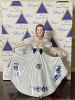 Front view of figurine against original Royal Dux box