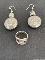 Full lot: two earrings and ring on black background