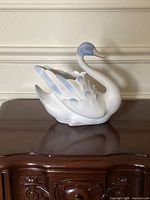 full view of porcelain swan planter on table