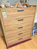 Front view of light wood five-drawer dresser with metal pulls