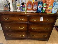 Front view of six-drawer wood dresser with brass handles
