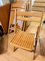 Front view of unfolded chair with others stacked behind