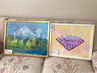 Both framed acrylic paintings side by side on sofa
