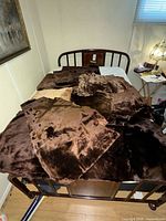 Multiple shearling hides laid out on bed showing colour variety and wool side
