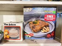 Boxed electric juicer and boxed Betty Crocker Microwave Mighty Sizzler browning skillet