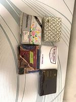 Group of five packaged sheet sets on mattress