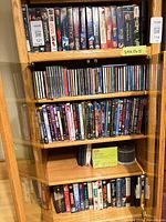 Cabinet with rows of VHS tapes, CDs, DVDs