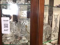 Cabinet view showing multiple crystal pieces and saucers
