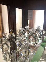 Assorted faceted crystal pineapples, perfume bottles, snowman and bud vase on mirrored shelf