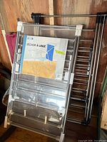 Packaged and loose drying racks leaning against wall