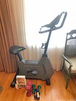 Exercise bike side view with dumbbells and boxed weights