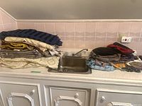 Two stacks of assorted folded fabrics beside sink