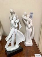 Three of the white ceramic figurines displayed together