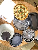 Overview of all items on table including salad spinner, mixing bowls, baking pans, decorative tray, cutting board